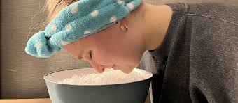 Woman applying ice cube treatment for open pores on face