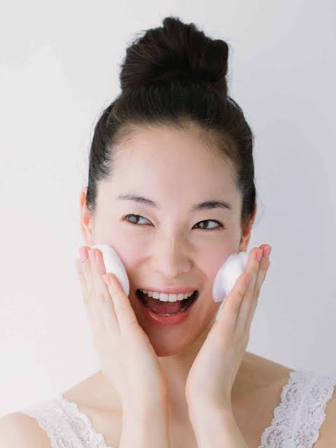 Woman following summer skincare routine to prevent open pores.